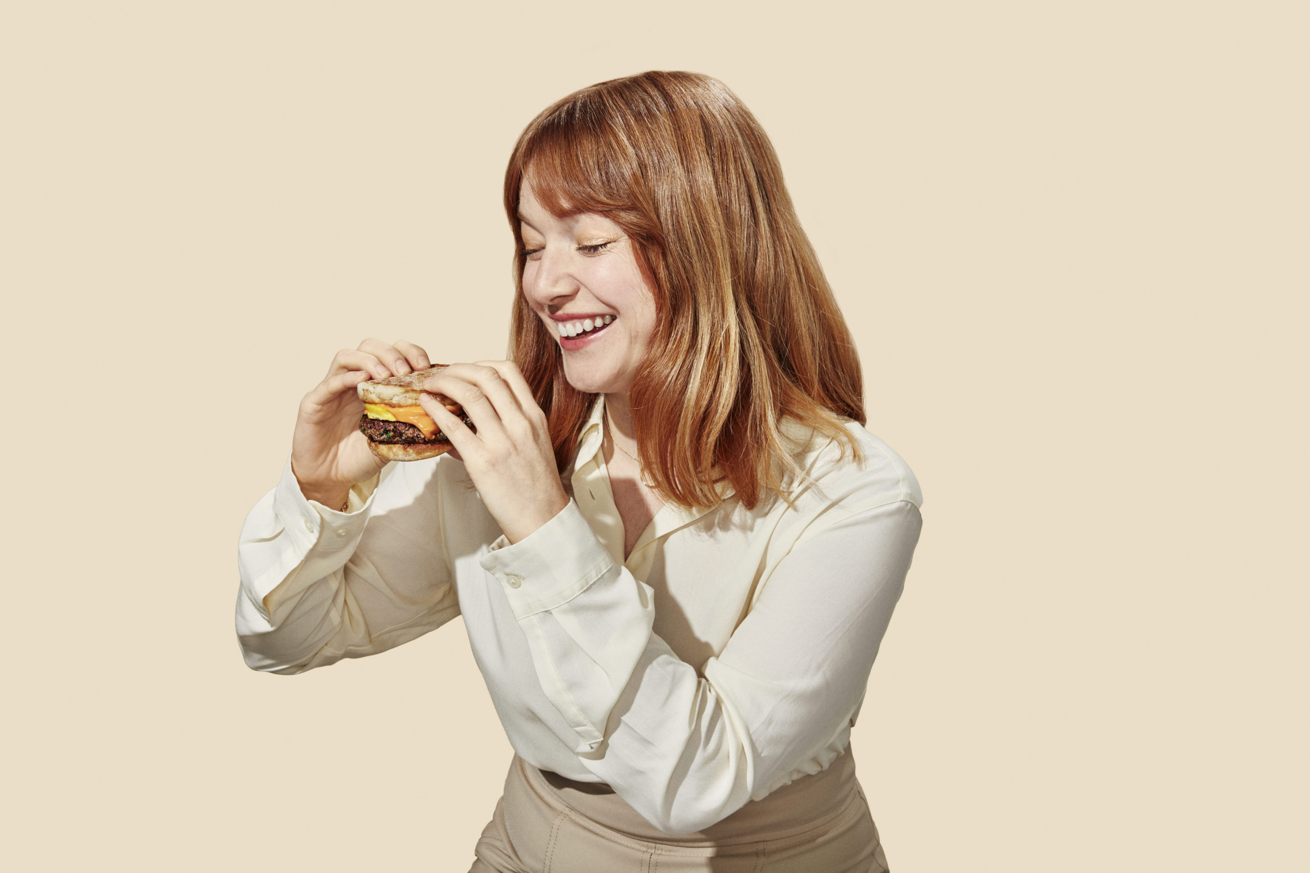 Woman eating plant-based meat burger created by Impossible Foods